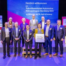 Ein Gruppenfoto mit circa 15 Personen vor der Bühne
