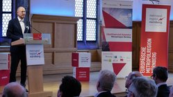 Mann referiert auf einer Veranstaltung vor Menschen