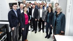 Gruppenfoto mit Männern im Anzug und Frauen in Blusen