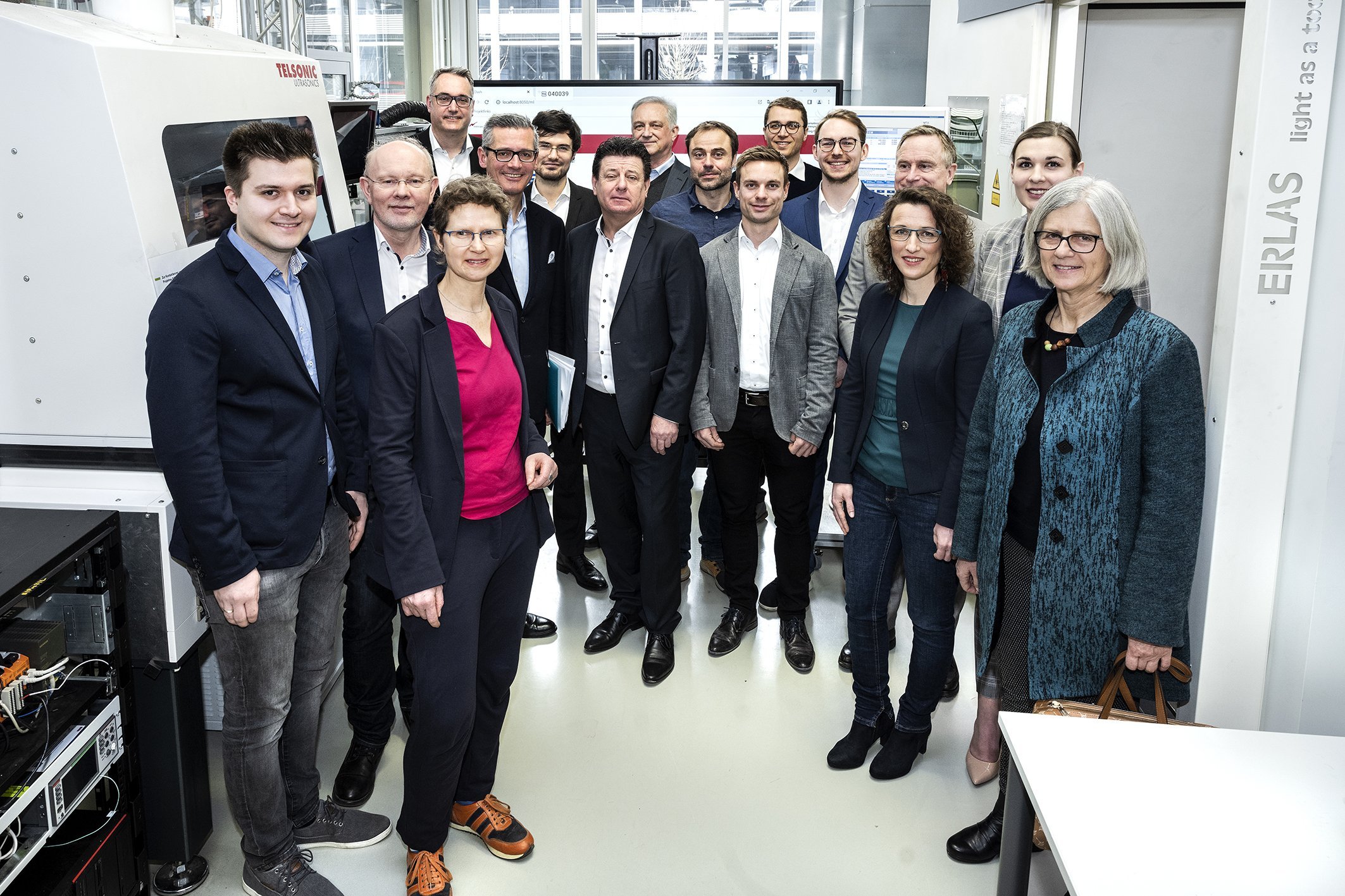 Gruppenfoto mit Männern im Anzug und Frauen in Blusen