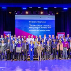 Ein Gruppenfoto mit sehr vielen Personen vor der Bühne