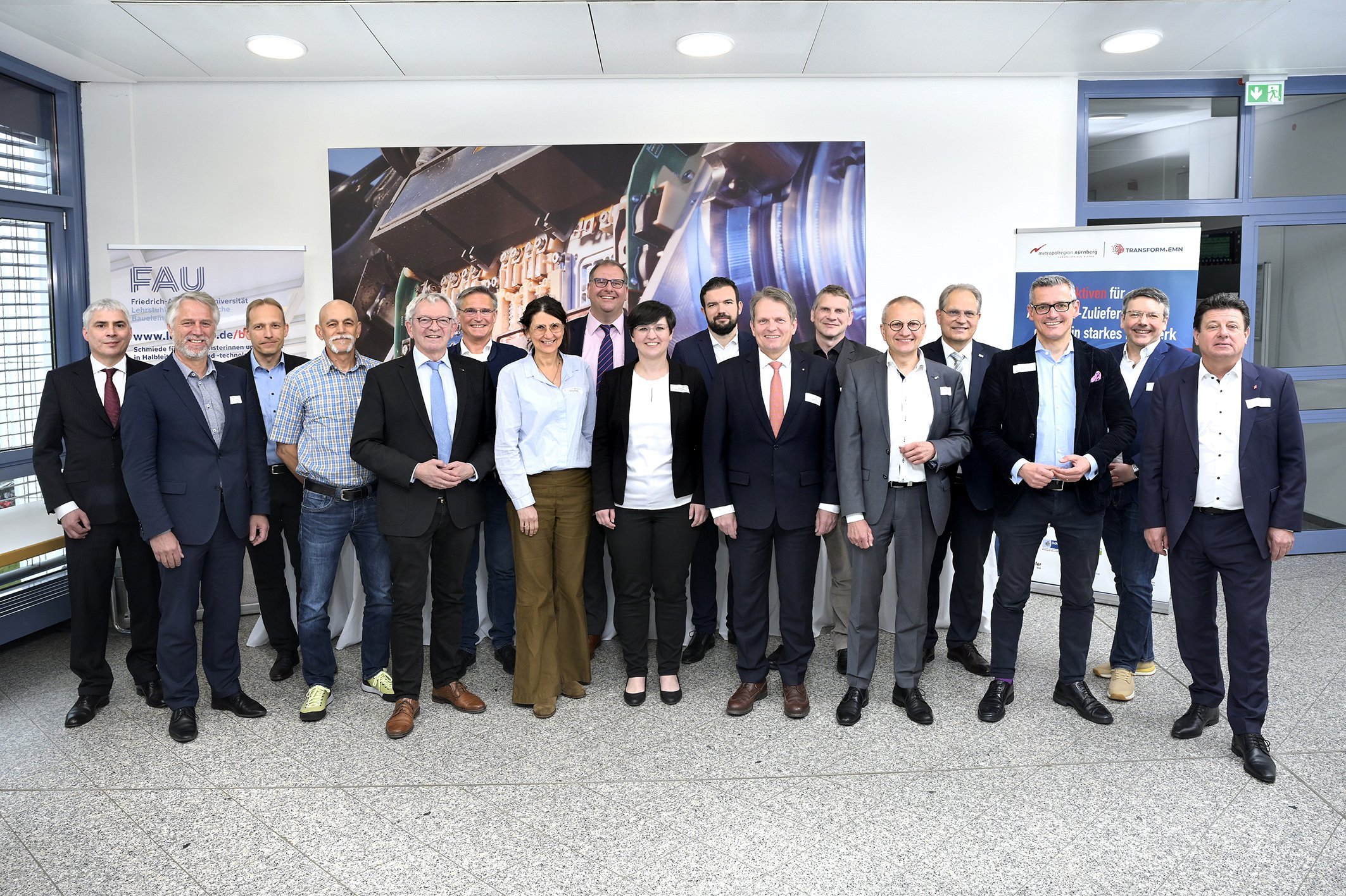 Gruppenbild mit Männern im Anzug und Frauen in Blusen